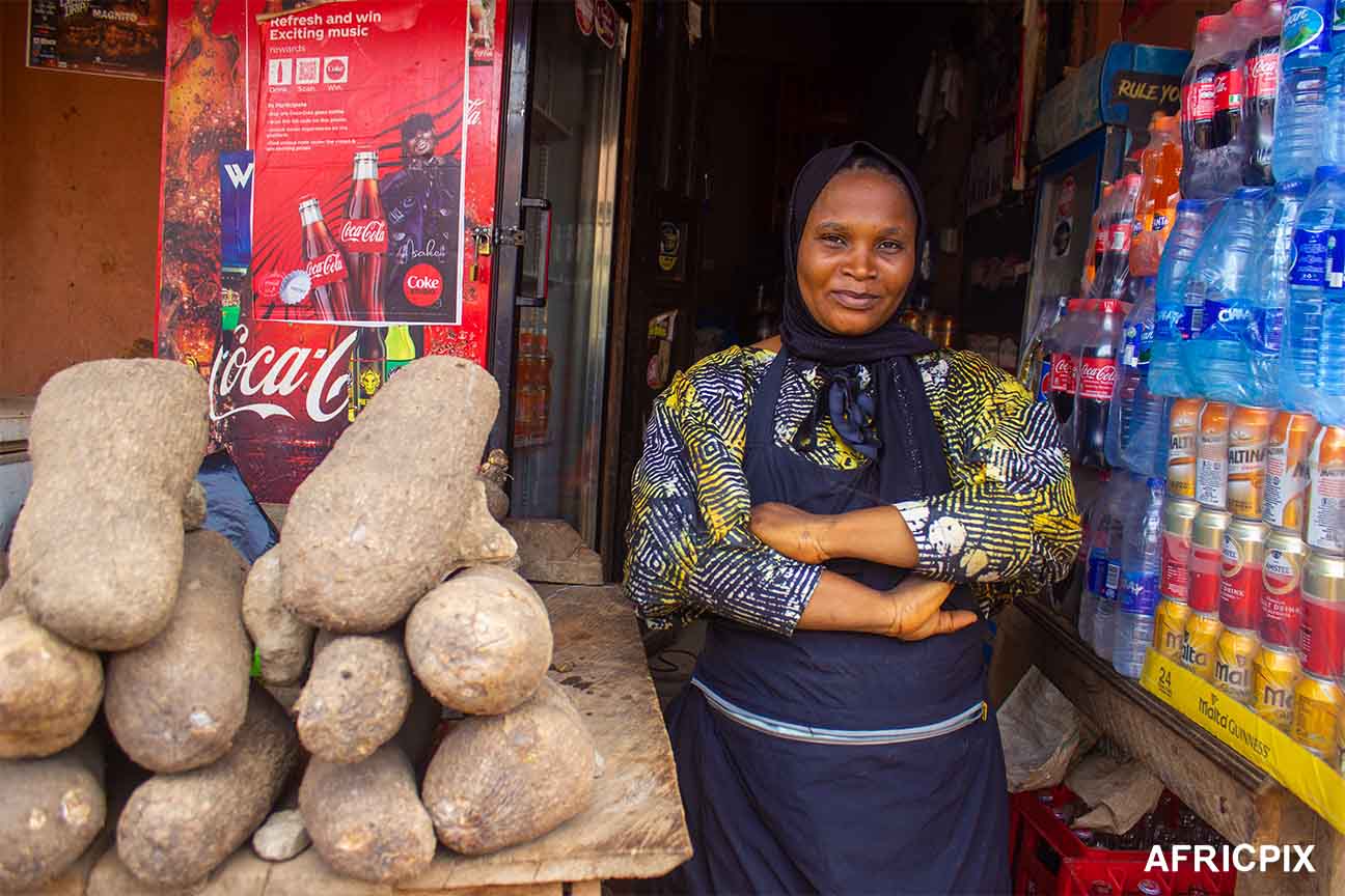 Nigeria Market Woman In Front of Shop smiling